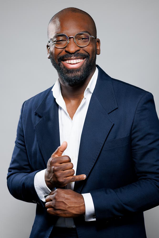 Homme souriant capturé en lumière naturelle pour un CV professionnel à Paris.