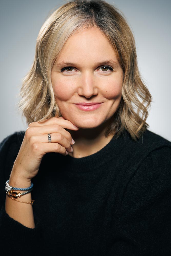 Expression naturelle et posture droite d’Adeline pour refléter la confiance au travail.