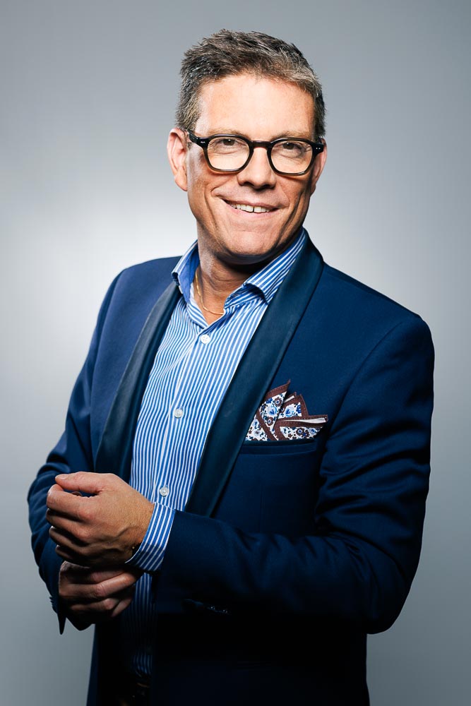 Portrait soigné d’un cadre en costume, fond neutre et atmosphère calme