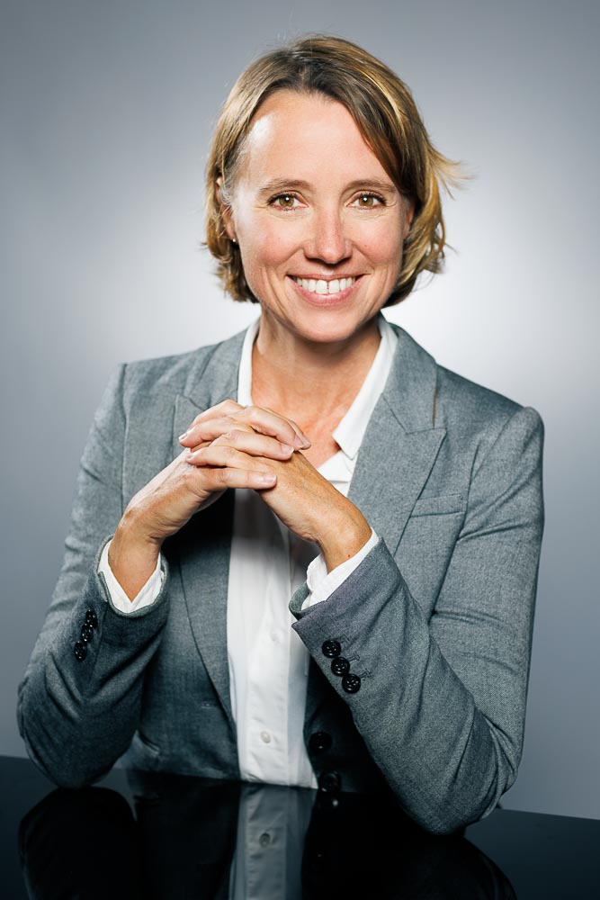 Photographe professionnel accompagnant un médecin pendant une séance photo personnalisée pour Doctolib avec conseils posture et regard
