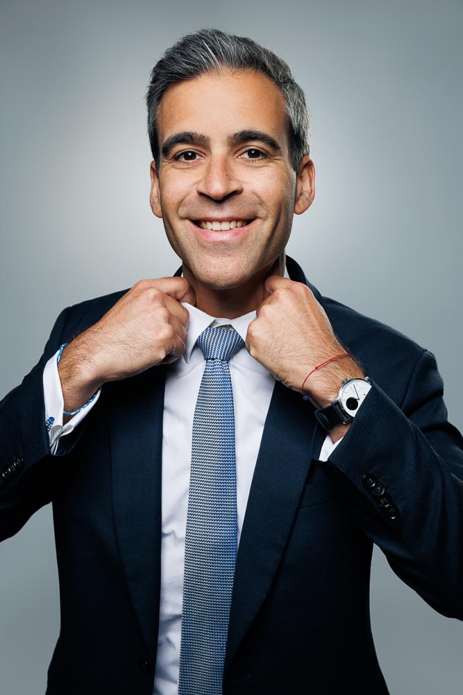 Visage d’un professionnel avec un regard confiant et une posture droite sur un fond uni