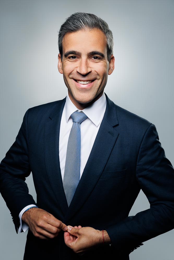 Portrait clair d’un professionnel avec un sourire naturel et un fond épuré