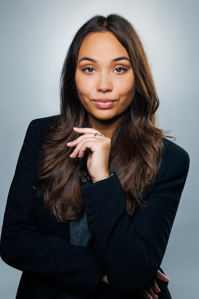 Portrait corporate d'Estelle avec posture droite et sourire naturel en ambiance studio.