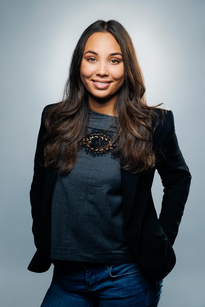 Estelle posant devant un fond sobre avec un éclairage doux valorisant ses traits.