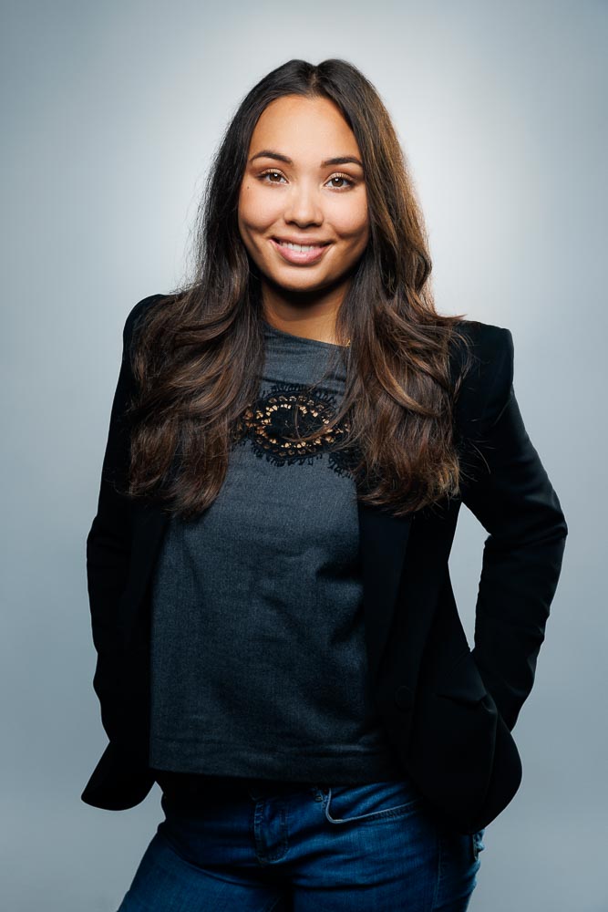 Portrait studio d'Estelle en tenue professionnelle, expression confiante et regard engageant.