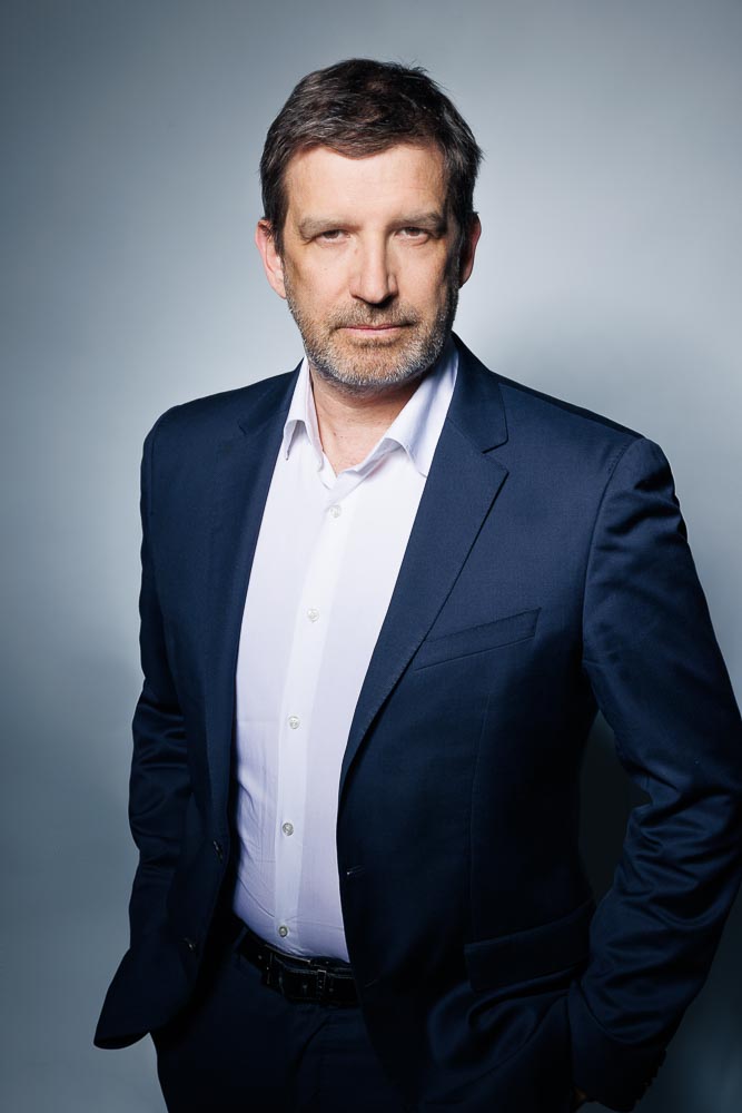 Chef d'entreprise dans un environnement minimaliste, valorisé par un éclairage dynamique.