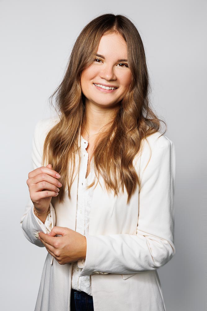 Cliché corporate studio avec lumière douce, posture élégante et attitude accessible pour usage professionnel