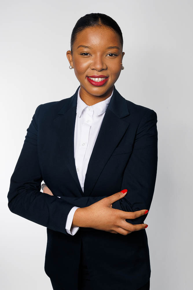 Image professionnelle d'une hôtesse de l'air dans une pose naturelle et confiante, fond neutre