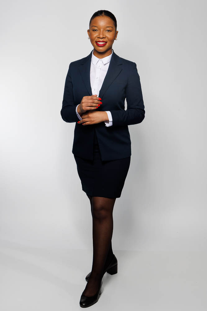 Image d'une steward en tenue professionnelle avec un fond sobre et lumineux à Paris