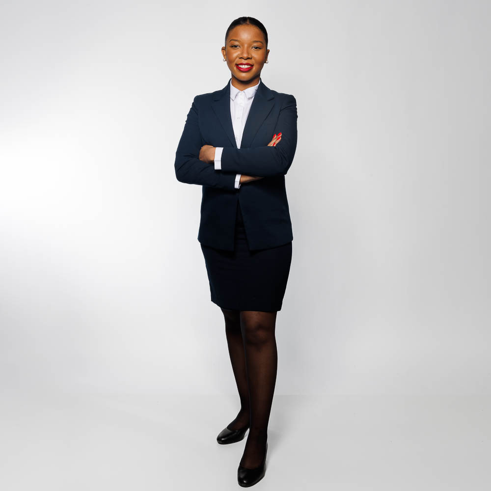 Hôtesse de l’air en tenue professionnelle, pose élégante en studio.