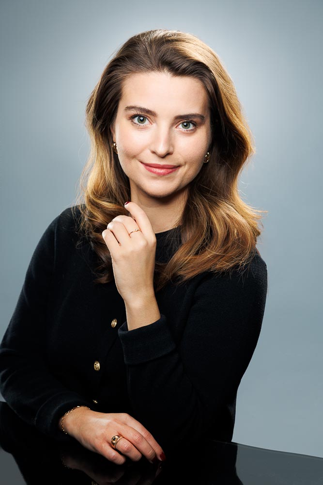 Capucine posant avec un léger sourire, lumière douce accentuant son visage