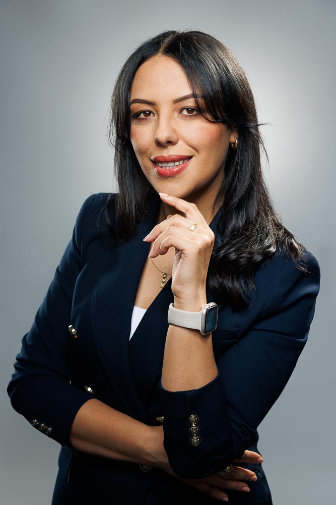 Portrait professionnel d'Améni avec un sourire naturel et regard confiant en studio parisien